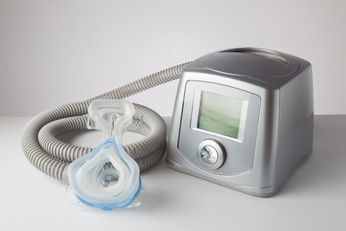 grey cpap machine sitting on white table