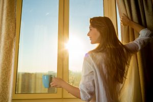 woman waking up early looking at the sun