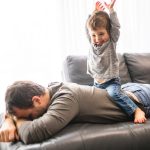 A,Tired,Young,Father,With,Boy,On,Back,A,Concept